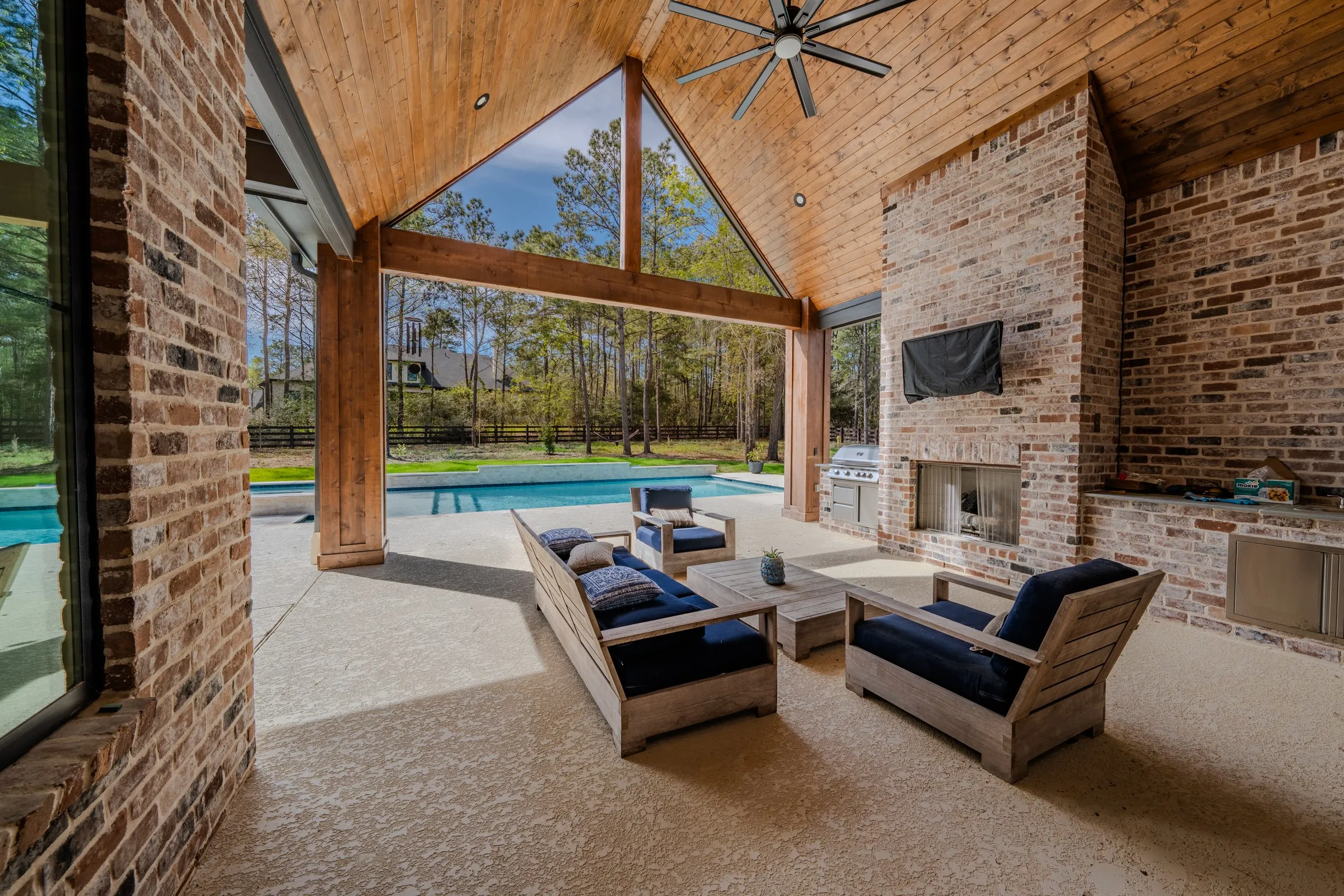 Covered outdoor living pavilion with fireplace and grill