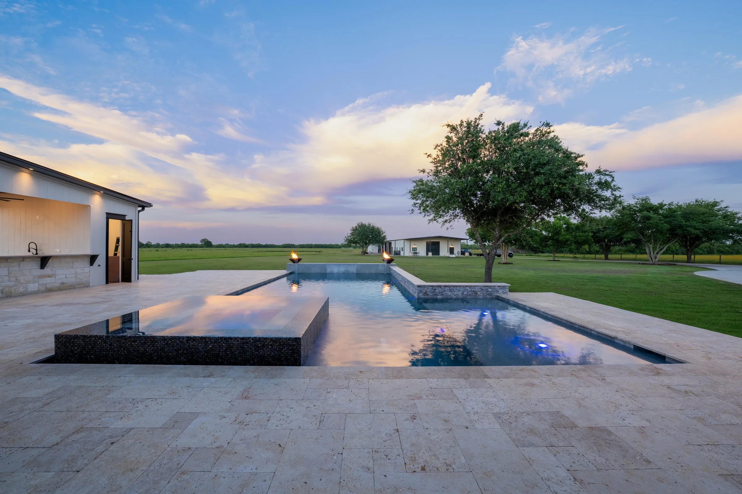 Finished backyard pool with fire feature at dusk