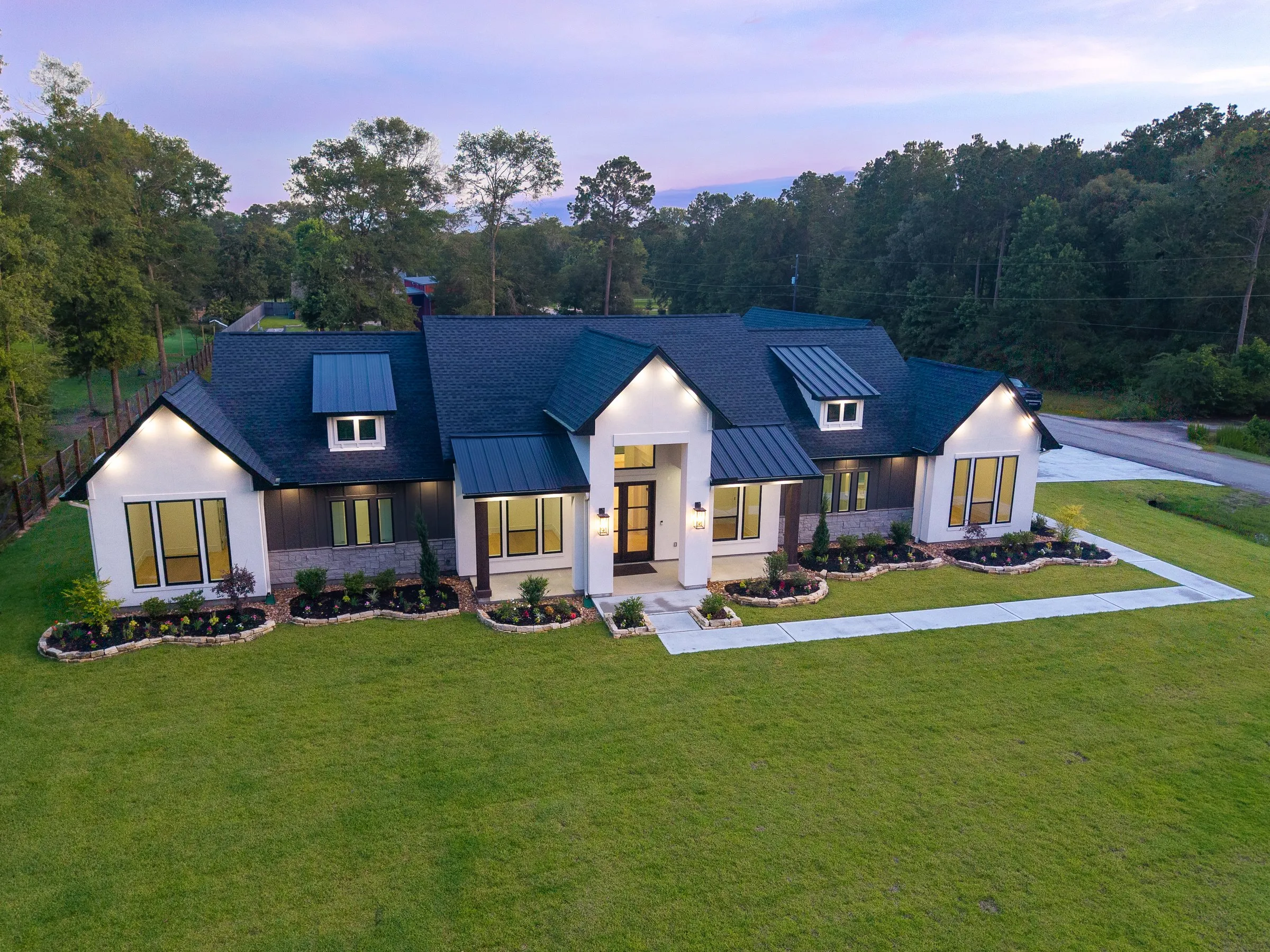 Aerial view of a completed home exterior and roofline at dusk
